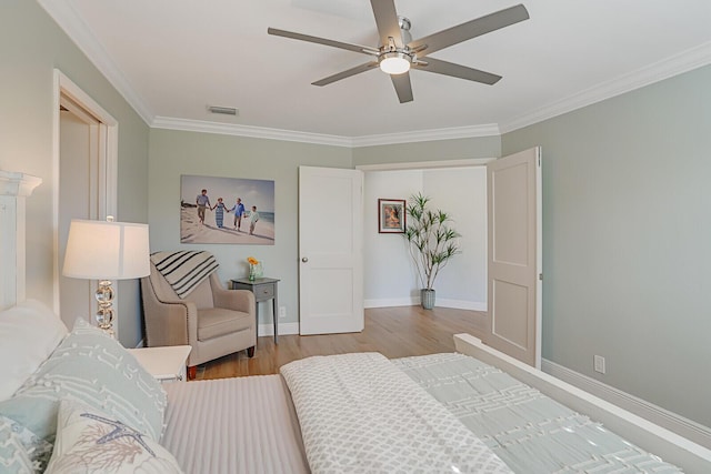 bedroom featuring baseboards, visible vents, a ceiling fan, wood finished floors, and crown molding