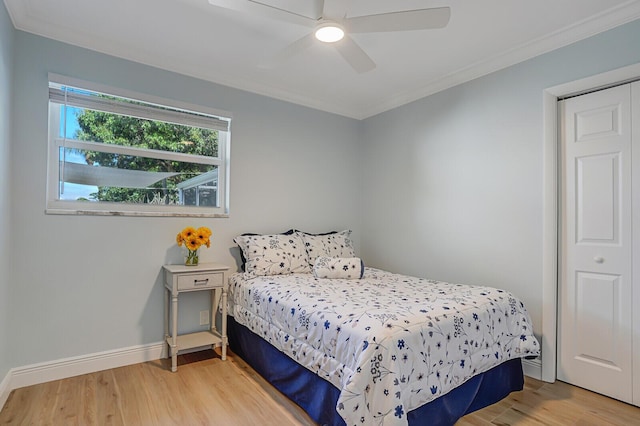 bedroom with light wood-style flooring, baseboards, ceiling fan, and crown molding