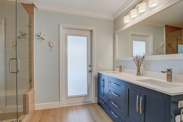 full bathroom with ornamental molding, a sink, and a shower stall