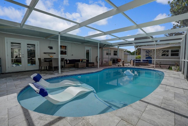 pool featuring french doors, outdoor lounge area, a hot tub, a patio area, and a lanai