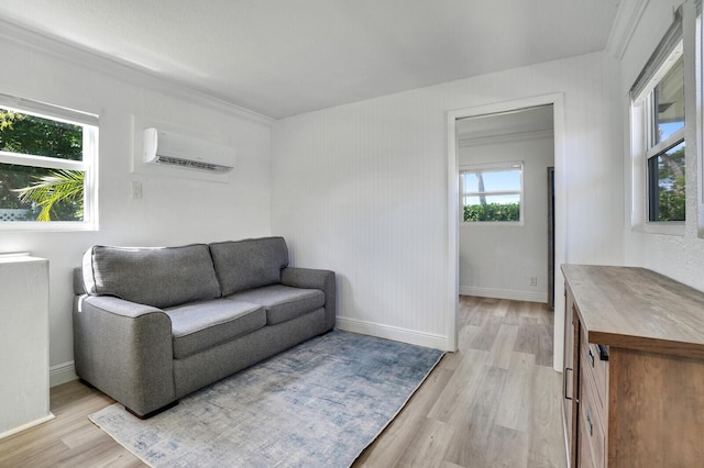 living area with light wood-style flooring, baseboards, and a wall mounted AC