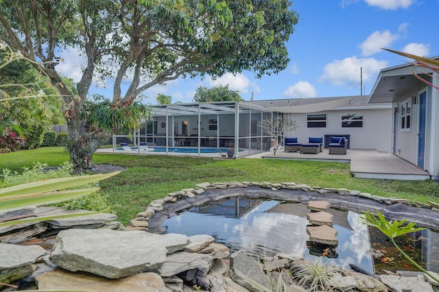 rear view of house with a yard, a patio, outdoor lounge area, glass enclosure, and an outdoor pool