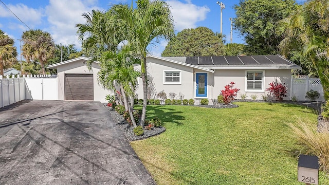 single story home featuring aphalt driveway, an attached garage, fence, a front yard, and stucco siding