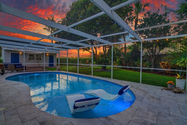 view of pool with a lanai, a lawn, and a patio