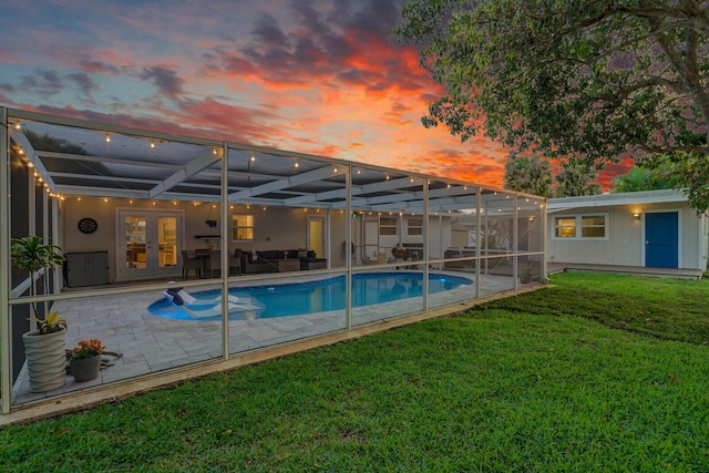 outdoor pool with a yard, french doors, a patio area, and a lanai