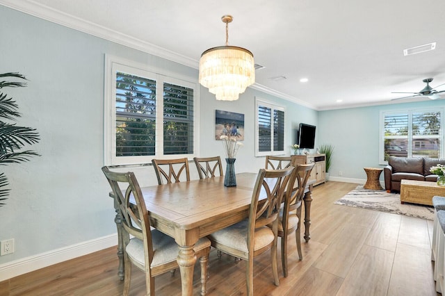 dining area with light wood-type flooring, visible vents, crown molding, and baseboards