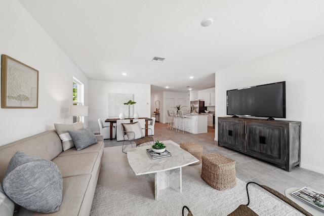 living area featuring recessed lighting, visible vents, and baseboards