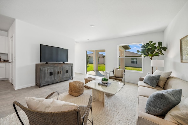 living area featuring light tile patterned flooring and baseboards