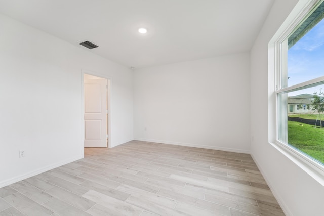 empty room featuring recessed lighting, light wood-type flooring, visible vents, and baseboards