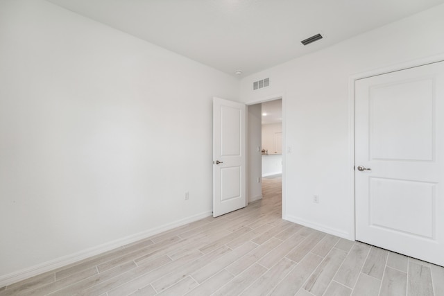 unfurnished bedroom with wood tiled floor, visible vents, and baseboards