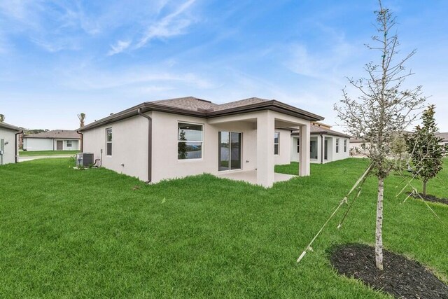 back of property featuring stucco siding, a patio, cooling unit, and a yard