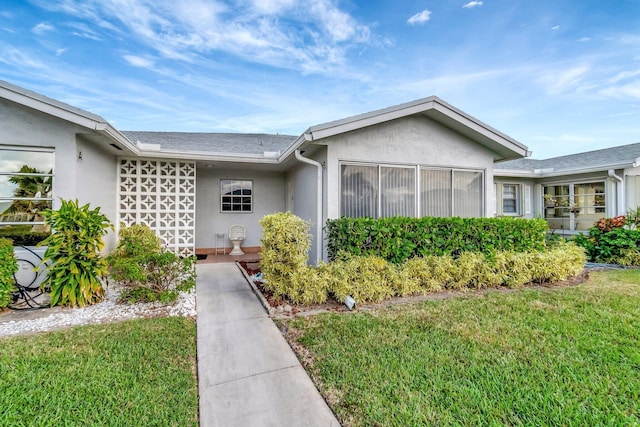 view of front of home featuring a front yard and stucco siding