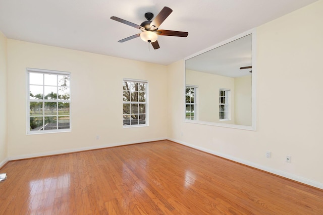 spare room featuring light wood-style flooring, baseboards, and ceiling fan