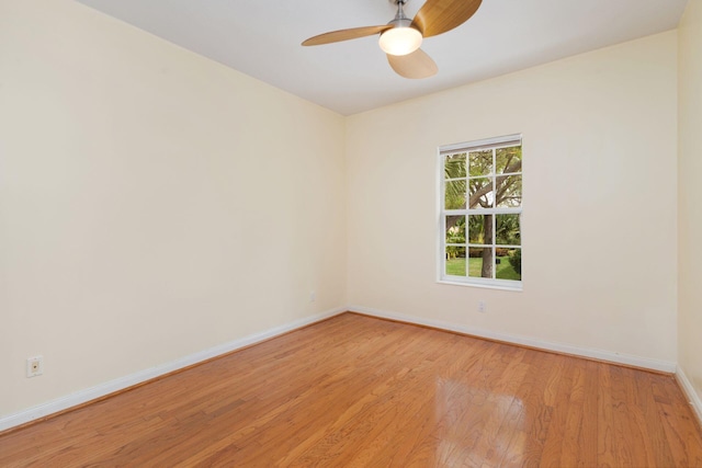 empty room with baseboards, ceiling fan, and light wood finished floors