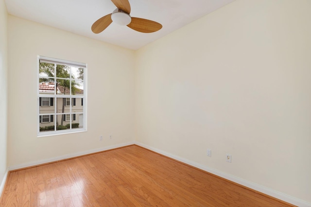 unfurnished room featuring light wood-type flooring, baseboards, and a ceiling fan