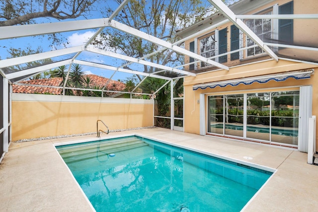 pool with glass enclosure and a patio