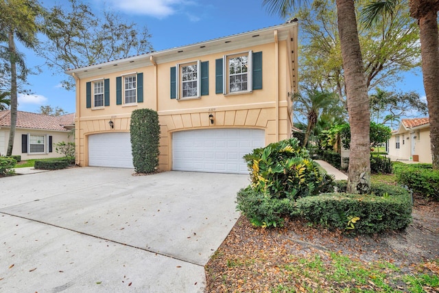 view of front of property featuring concrete driveway, an attached garage, and stucco siding