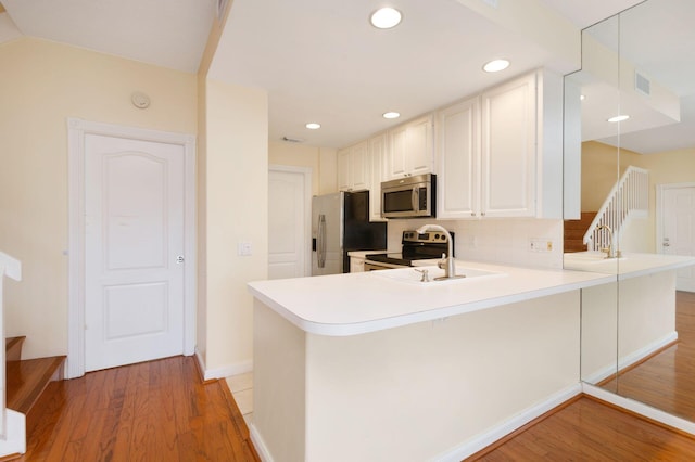 kitchen with a peninsula, light countertops, and stainless steel appliances