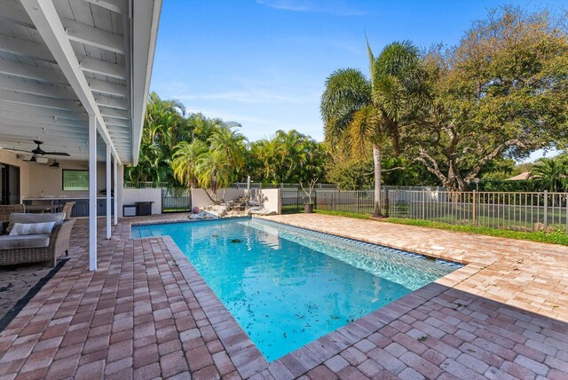 view of swimming pool featuring a patio area, ceiling fan, fence, and a fenced in pool