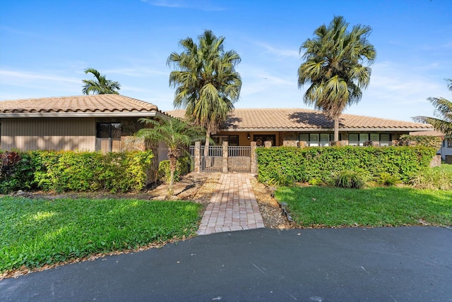 view of front of home featuring a tile roof, a gate, and fence