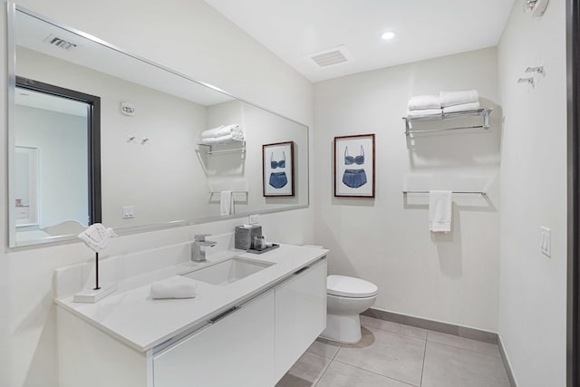 bathroom featuring toilet, vanity, baseboards, visible vents, and tile patterned floors