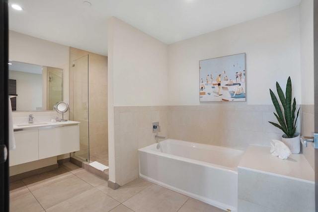 bathroom featuring a garden tub, tile walls, a stall shower, vanity, and tile patterned flooring