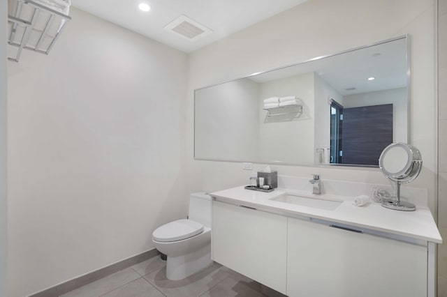 bathroom featuring baseboards, visible vents, toilet, tile patterned floors, and vanity