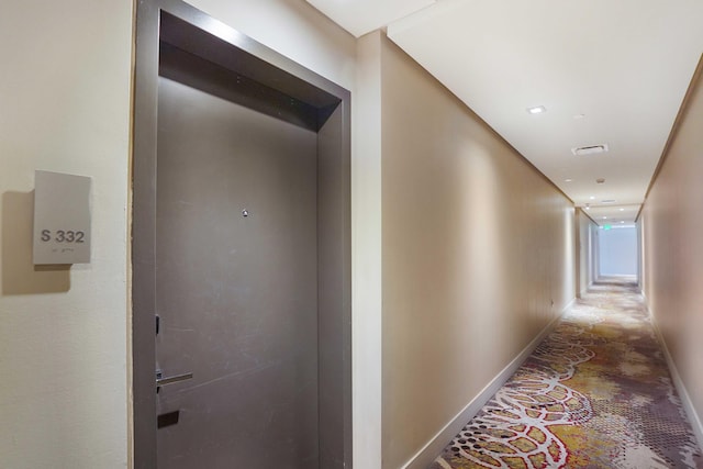 hallway featuring baseboards and visible vents