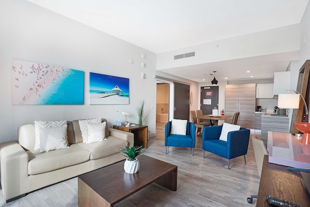 living area featuring light wood finished floors and visible vents