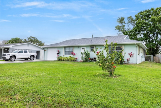 ranch-style home with a garage, driveway, fence, a front yard, and stucco siding