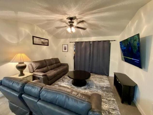 living room with ceiling fan and baseboards