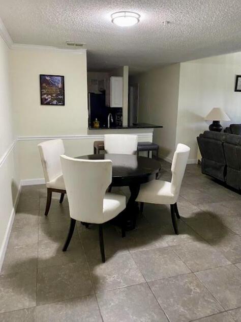 dining area with baseboards and a textured ceiling