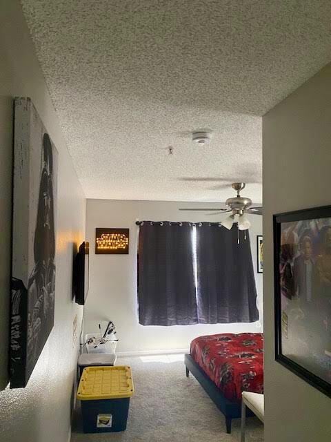 carpeted bedroom with a textured ceiling