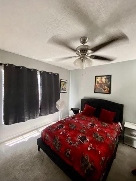 carpeted bedroom featuring a ceiling fan and a textured ceiling