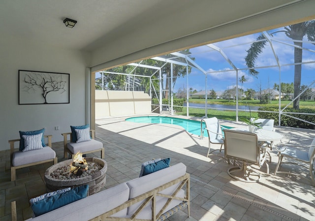 outdoor pool with a lanai, a patio, a water view, and a fire pit