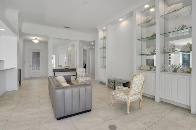 sitting room featuring built in shelves, crown molding, and light tile patterned floors