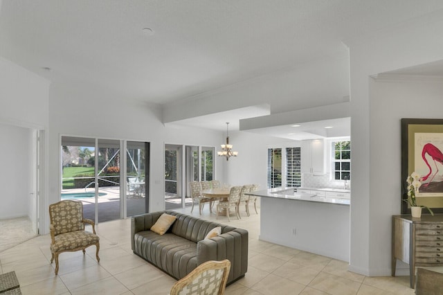 living area with a chandelier, ornamental molding, and a healthy amount of sunlight