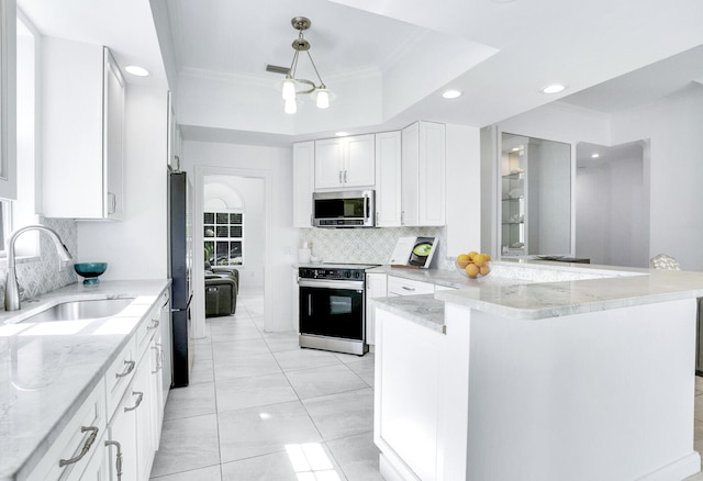 kitchen with ornamental molding, a sink, stainless steel microwave, tasteful backsplash, and electric stove