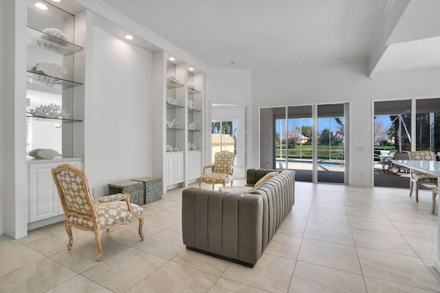 living area with built in shelves, light tile patterned flooring, and crown molding