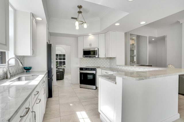 kitchen featuring a peninsula, electric range, a sink, white cabinets, and stainless steel microwave