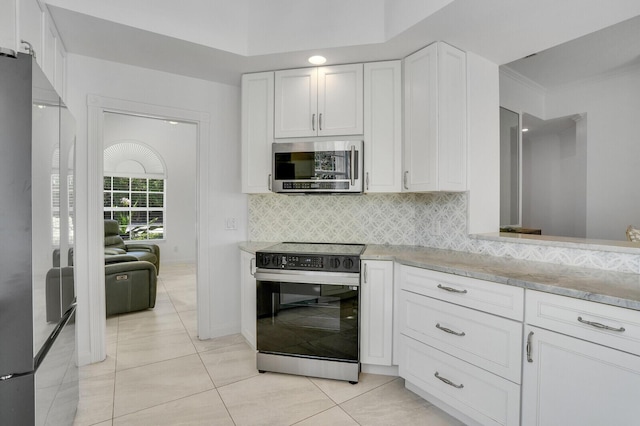 kitchen featuring light tile patterned floors, appliances with stainless steel finishes, white cabinetry, and tasteful backsplash