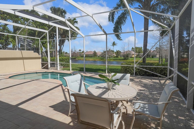 pool with glass enclosure, a water view, and a patio