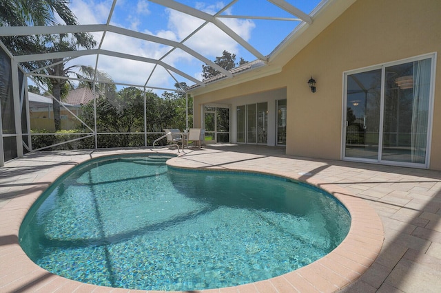 outdoor pool featuring a patio and glass enclosure