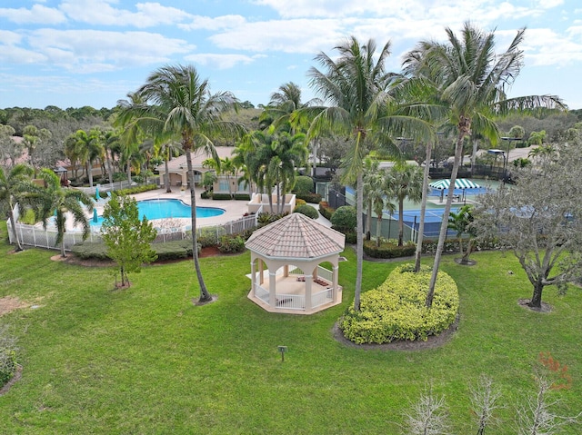 exterior space featuring a pool, a yard, a gazebo, and fence