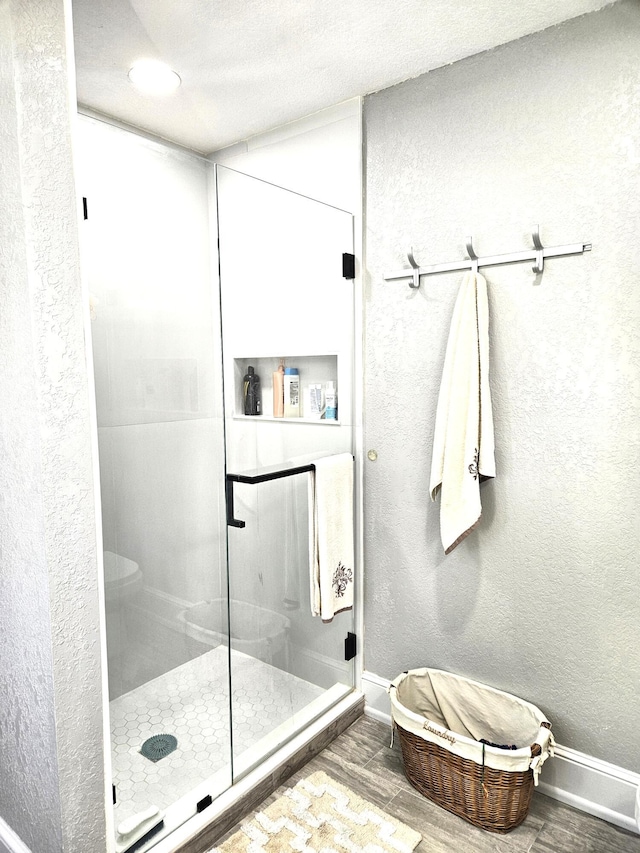 206 Edgewood Dr, West Palm Beach, FL 33405 - full bathroom featuring a stall shower, wood finished floors, baseboards, and a textured wall