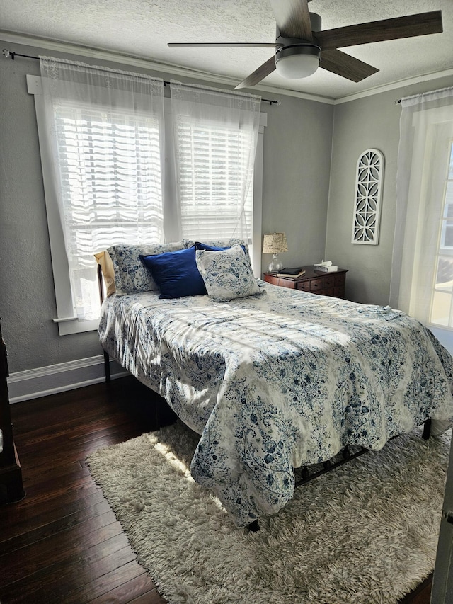 bedroom with wood-type flooring, ornamental molding, ceiling fan, a textured ceiling, and baseboards