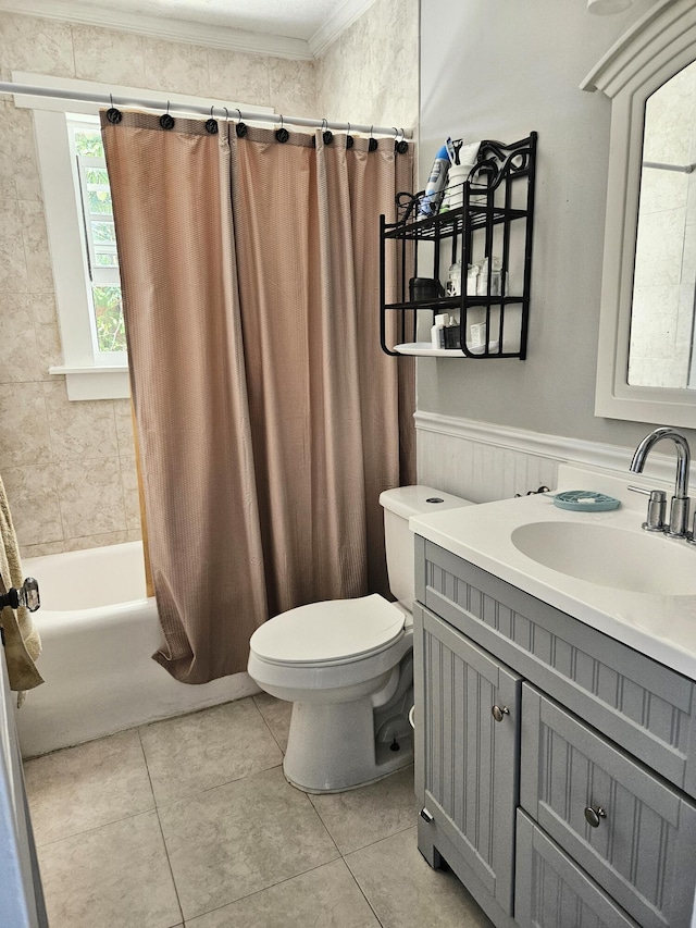 full bathroom with a wainscoted wall, toilet, shower / bath combo, vanity, and tile patterned flooring