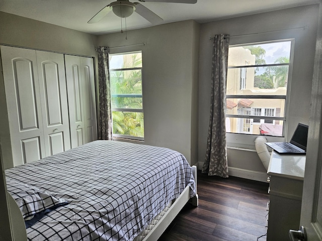 bedroom with dark wood-style floors, a closet, a ceiling fan, and baseboards