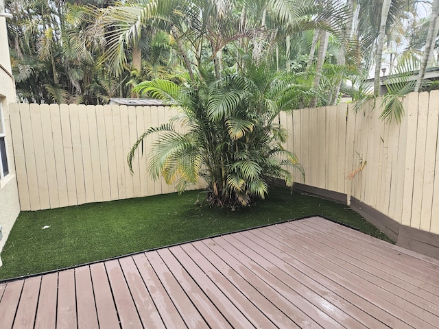 wooden terrace with a lawn, a fenced backyard, and radiator