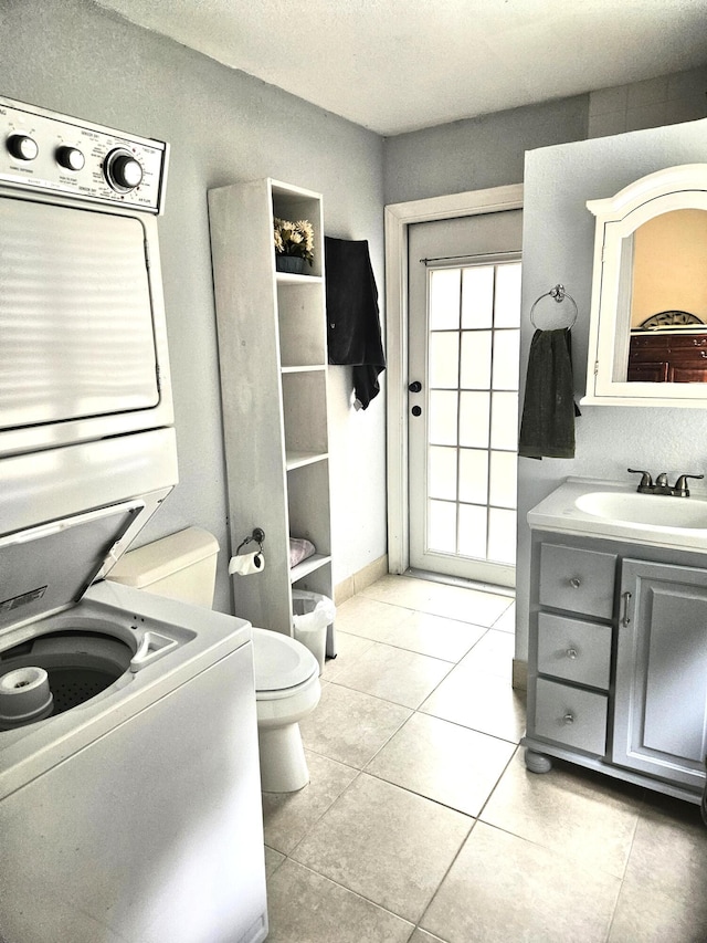 206 Edgewood Dr, West Palm Beach, FL 33405 - bathroom with tile patterned floors, toilet, vanity, and stacked washing maching and dryer